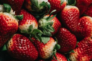 Fresh ripe strawberries with green leaves close-up