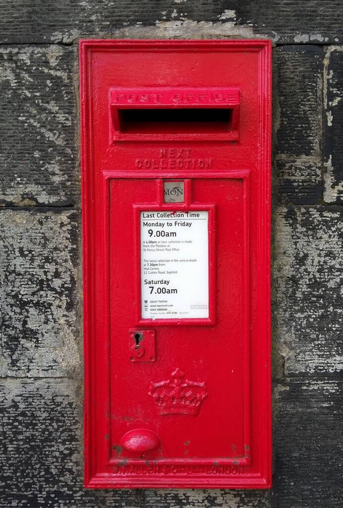 Boîte aux lettres rouge sur mur en pierre